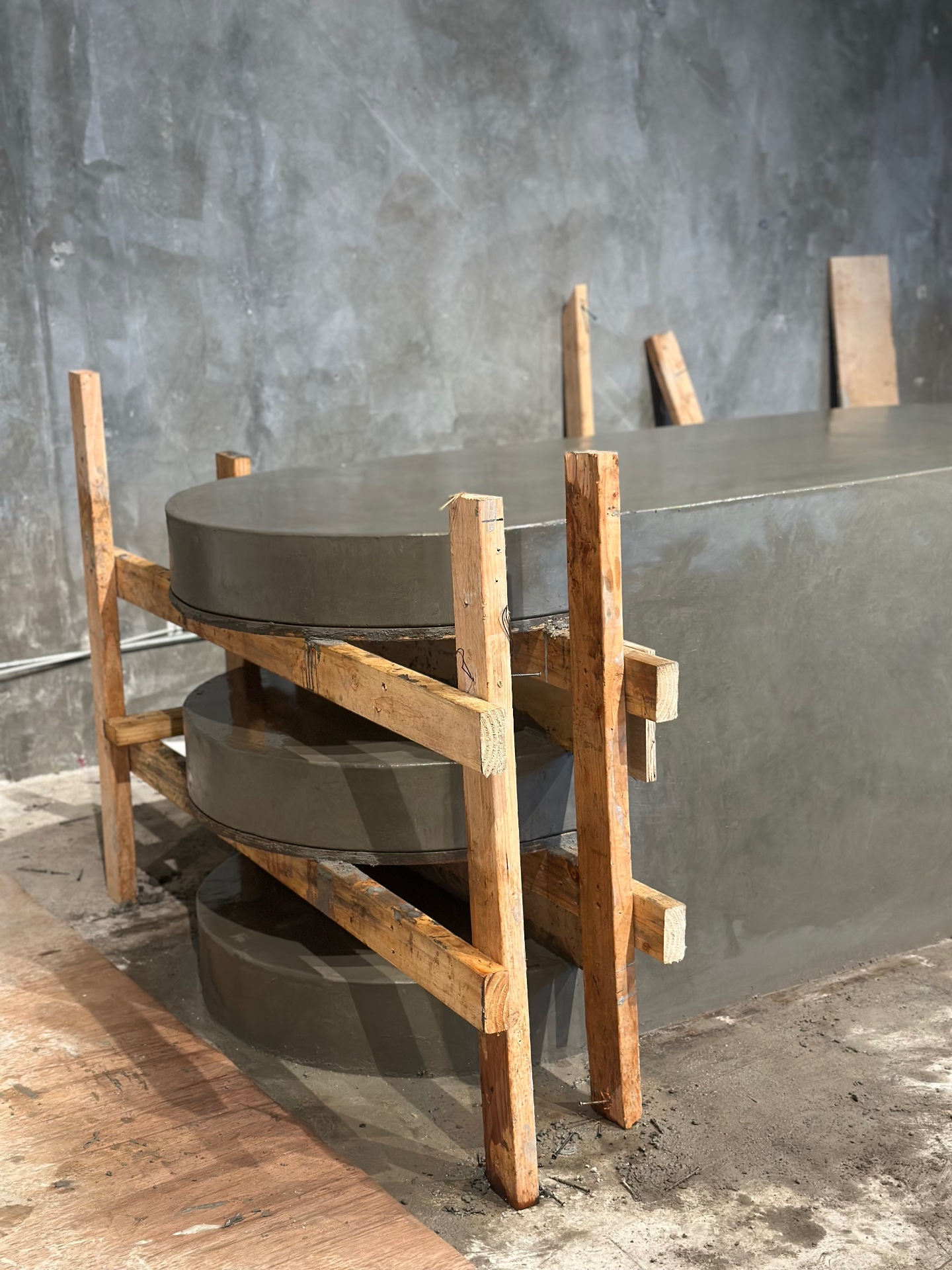 Stacked timber formwork bracing a curing micro-concrete bar, fabricated by Driftwood